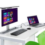 Flip top desk with 1 monitor hidden inside the desk and 1 monitor in the up position ready for use